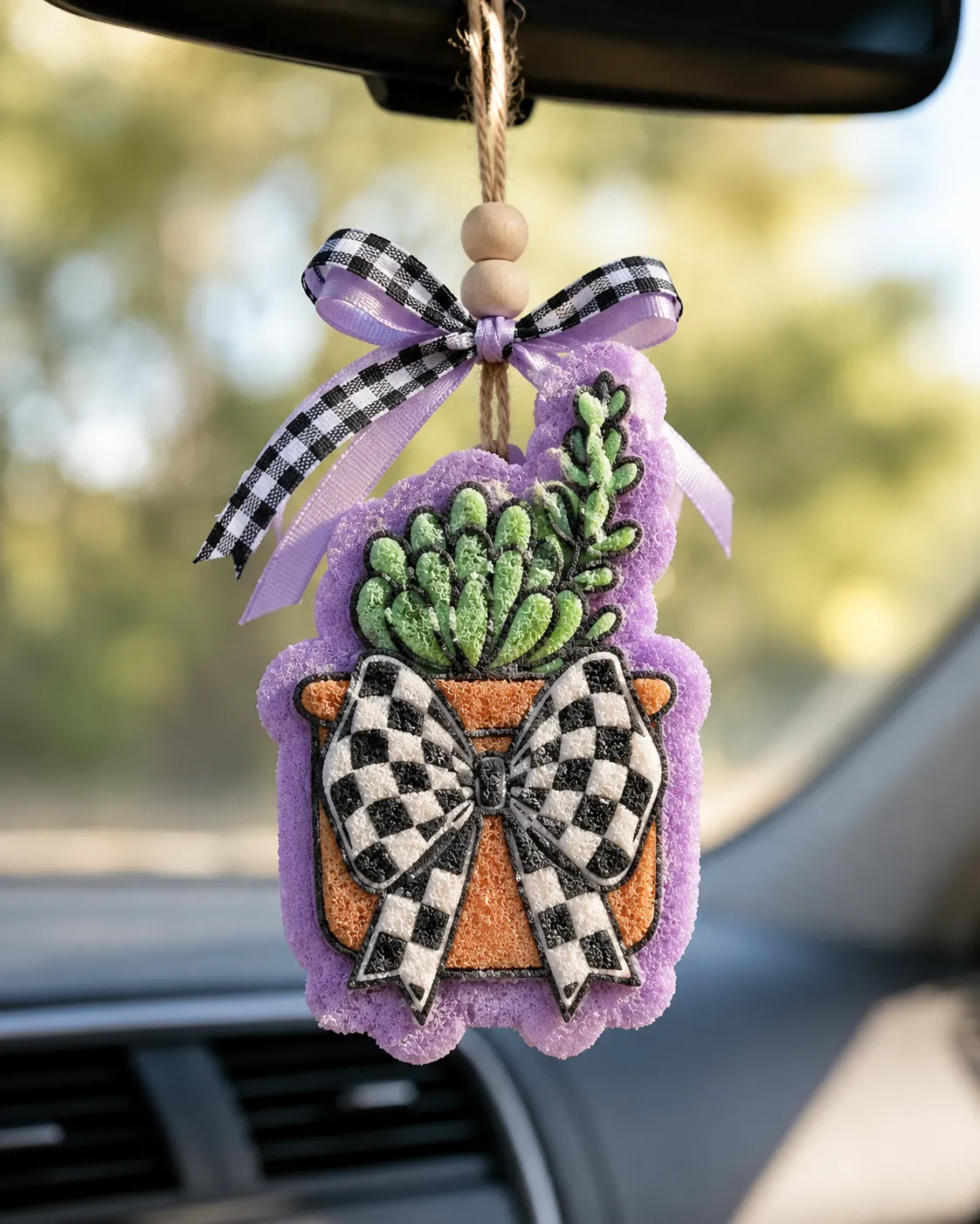 Handmade potted succulent car freshie with a green succulent plant and a trendy black and white checkered bow, a scented aroma bead air freshener for hanging on a car rearview mirror.