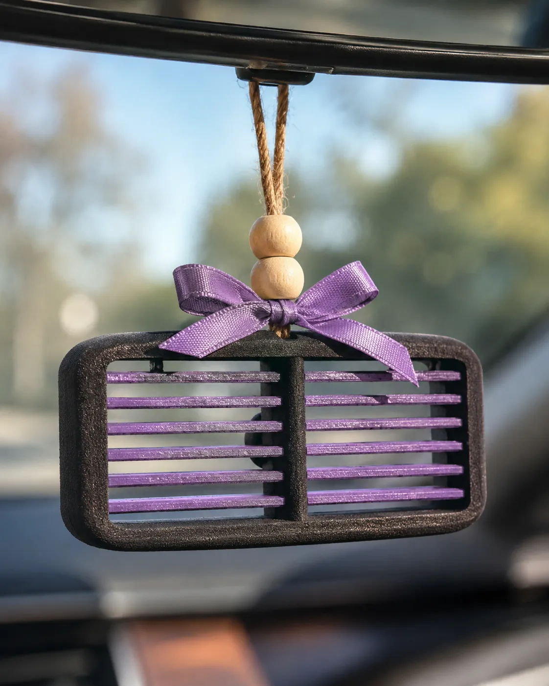 Handmade western country car vent freshie, a scented aroma bead air freshener clipped onto a car AC vent.