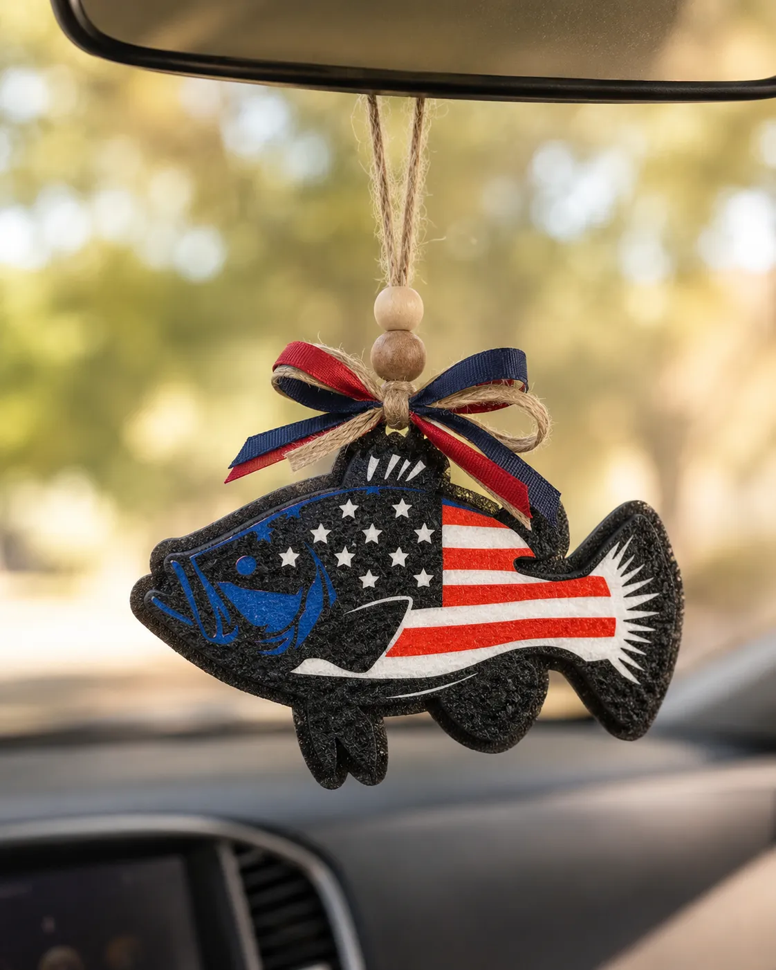Handmade patriotic USA fish-shaped freshie car air freshener decorated in red, white, and blue American flag colors, made of scented aroma beads with a hanging loop for a rearview mirror.