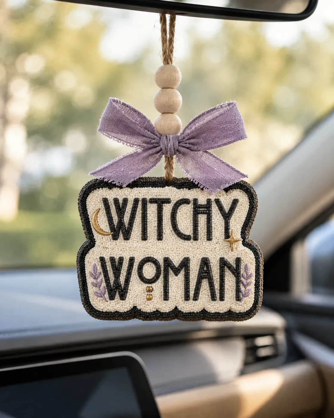 Handmade Witchy Woman freshie, a western witch themed scented aroma bead car air freshener with boho cowgirl Halloween styling hanging from a car rearview mirror.
